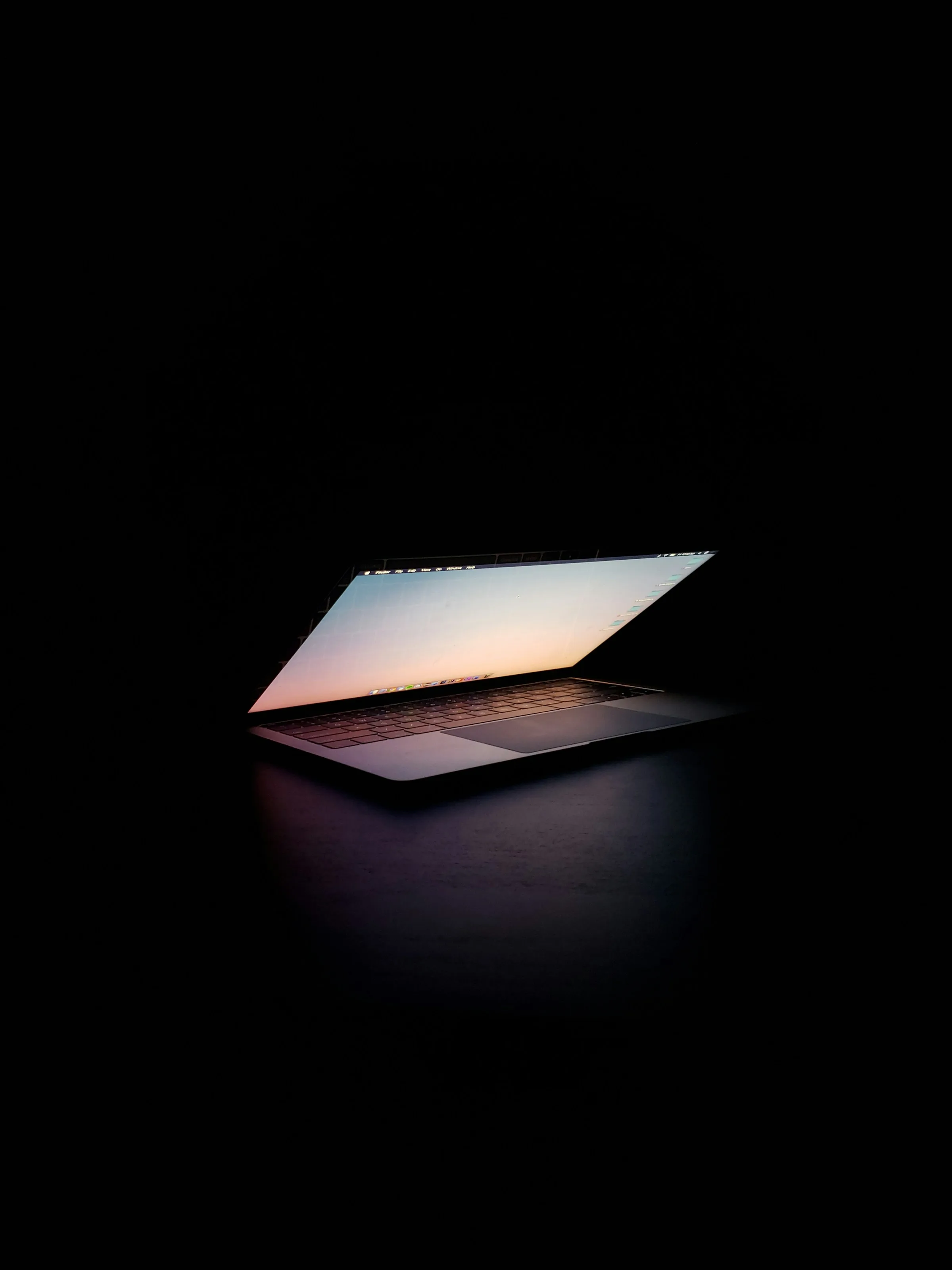 Laptop screen glowing in a dark workspace
